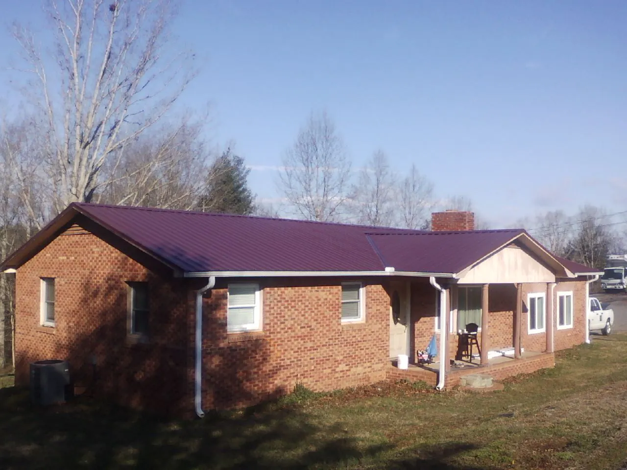 Burgundy metal roof on a brick ranch home with a new addition in Bruin