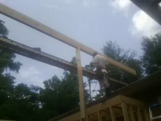 Carpenter setting a ridge beam over a new addition frame — Ice Dam Removal by Roofing Brothers in Bruin