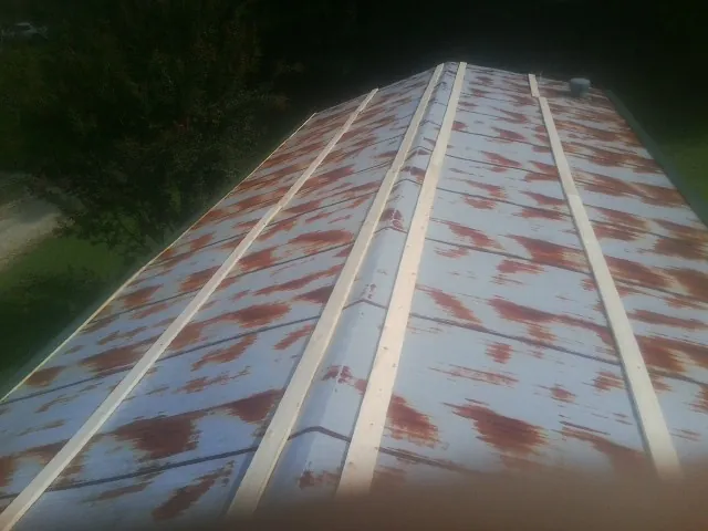 Rusted metal roof panels with new wood purlins before replacement — Storm Damage Roof Repair in Bruin by Roofing Brothers