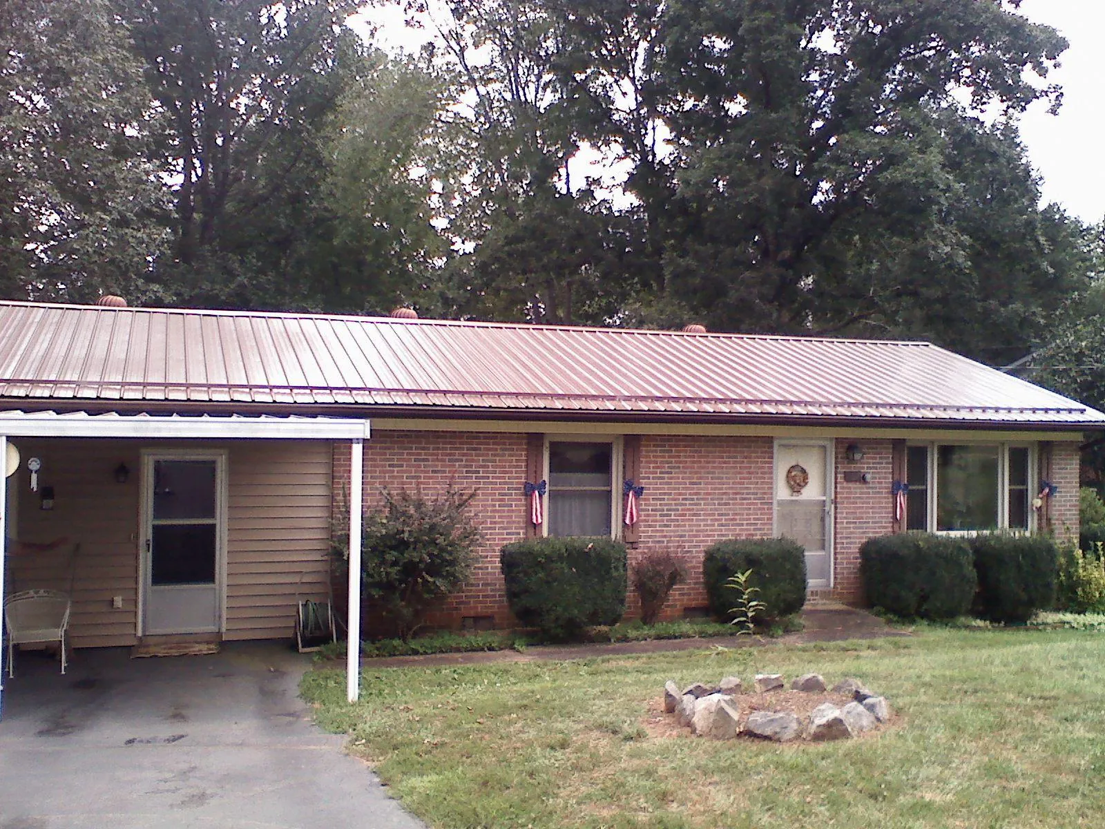 Bronze metal roof and carport on a brick ranch home — Roof Repair work by our crew in Bruin